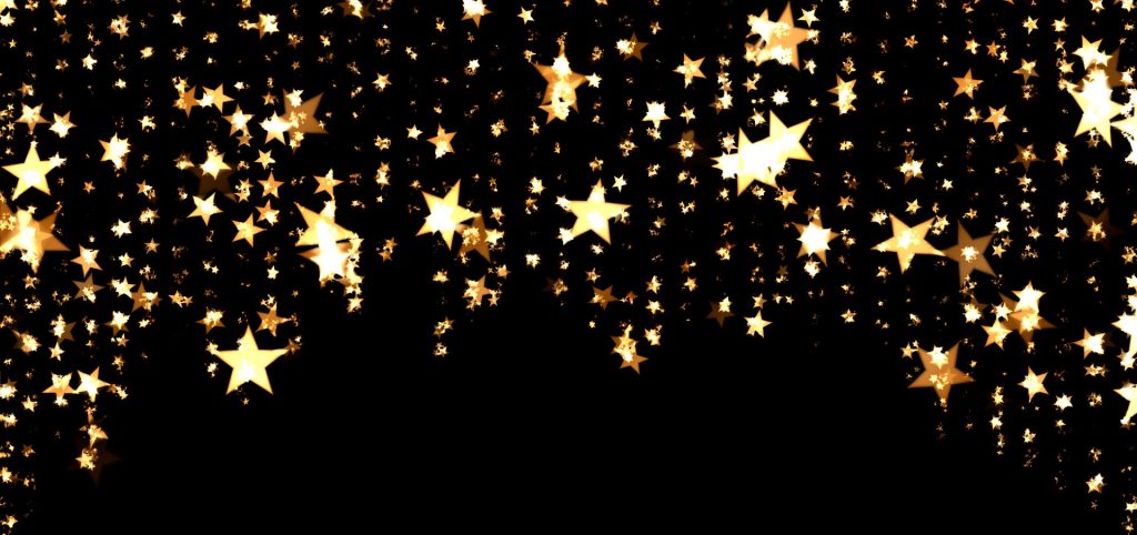 streams of gold stars cascade from the ceiling against a black background