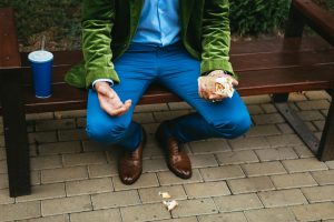 Man on park bench, holding a half-eaten wrap