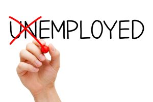 Find a new job. Hand turning the word Unemployed into Employed with red marker isolated on white.